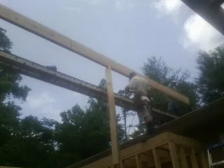 Carpenter setting a ridge beam over a new addition frame — Ice Dam Removal by Roofing Brothers in Horseshoe Bay