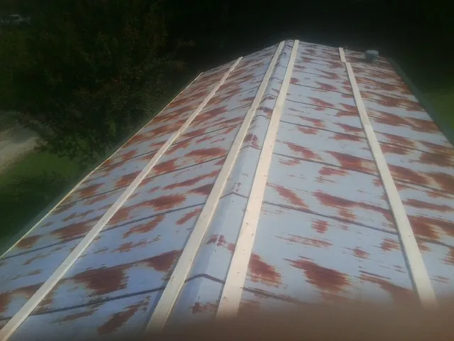 Rusted metal roof panels with new wood purlins before replacement — Storm Damage Roof Repair in Horseshoe Bay by Roofing Brothers