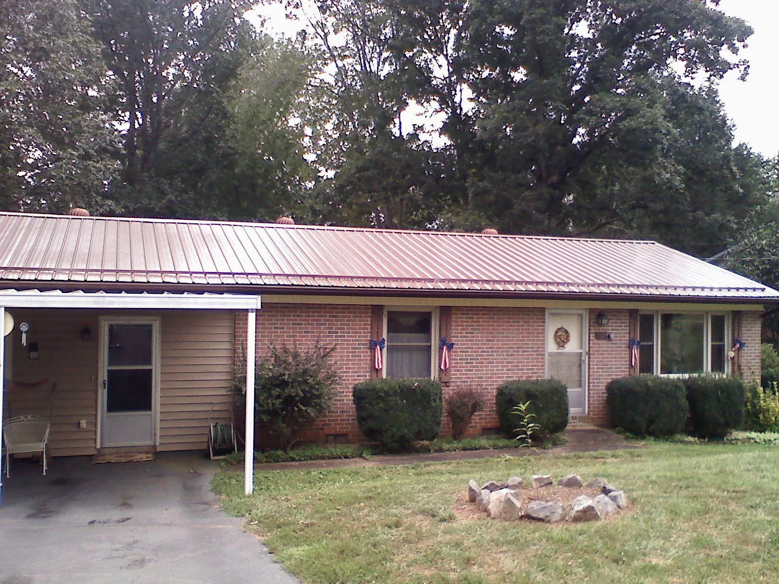 Bronze metal roof and carport on a brick ranch home — Roof Repair work by our crew in Horseshoe Bay