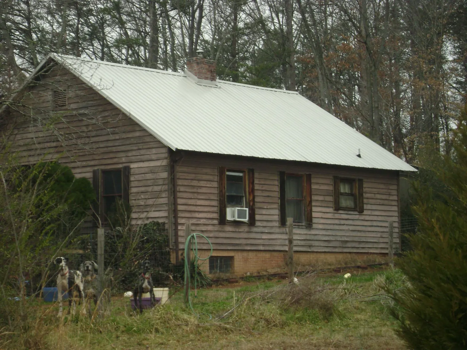 White metal roof on an old wood sided farmhouse, from a Metal Roof Installation job in Horseshoe Bay